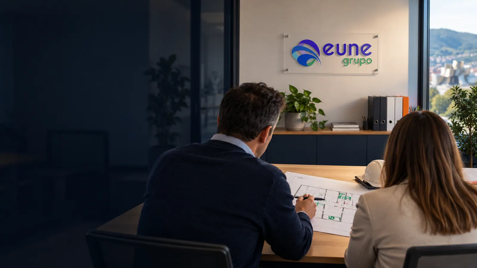 Escena ilustrativa de una consulta profesional sobre autoprotección, con el logotipo de Grupo Eune en la pared